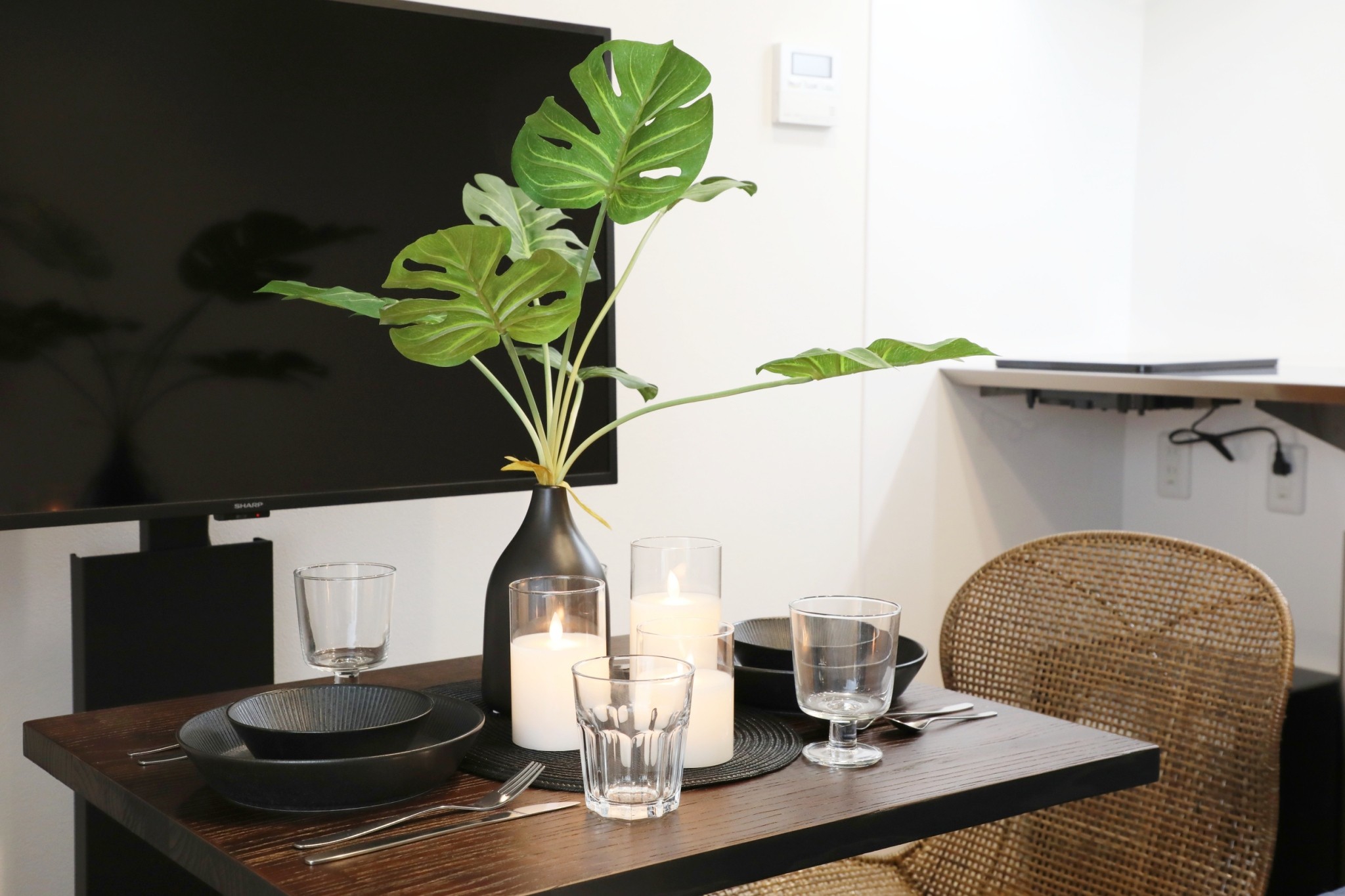 Room 202 dining table with rattan chairs and candles
