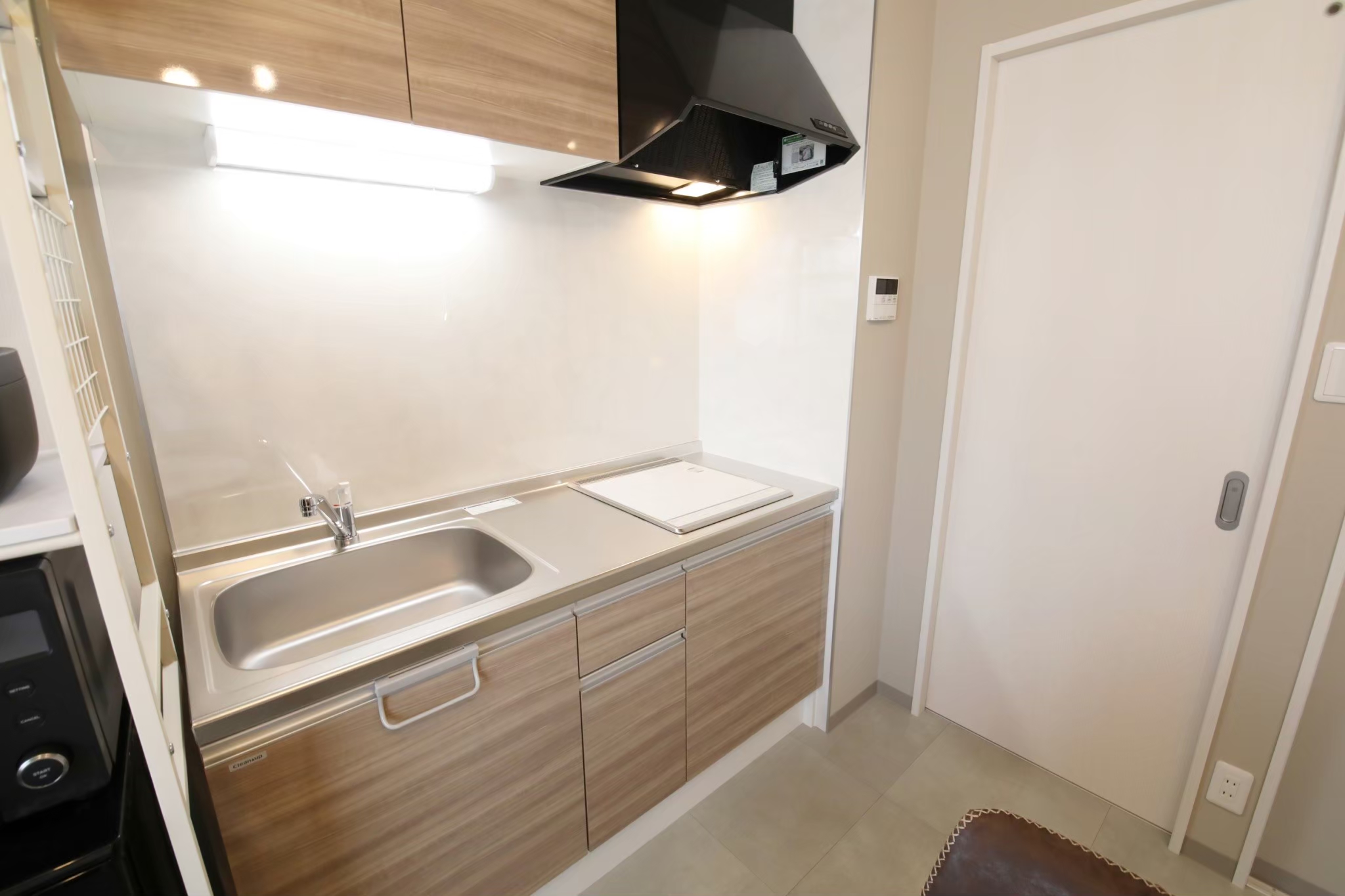 Room 103 kitchen sink and wood-tone cabinets